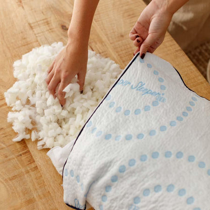 Person filling an Every Comfort Pillow with Stuffing
