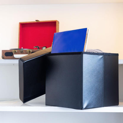 Black Collapsible Ottoman on a step with books inside and a record player behind