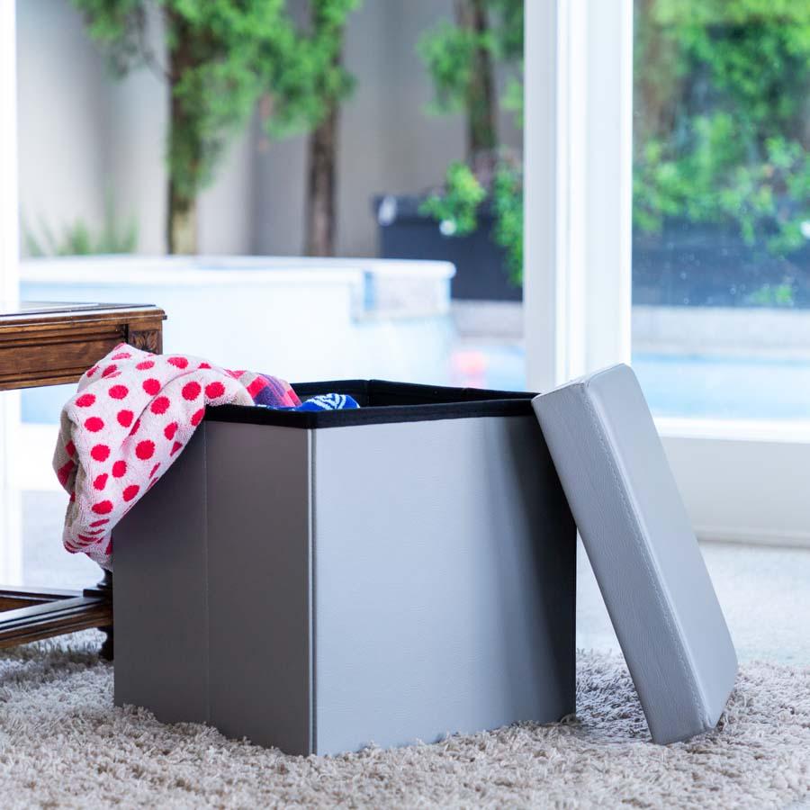 Grey Collapsible Ottoman filled with the lid off in a living room