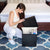 Woman looking into a full Black Collapsible Ottoman infront of a bed