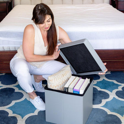 Woman in a bedroom opening the Grey Collapsible Ottoman