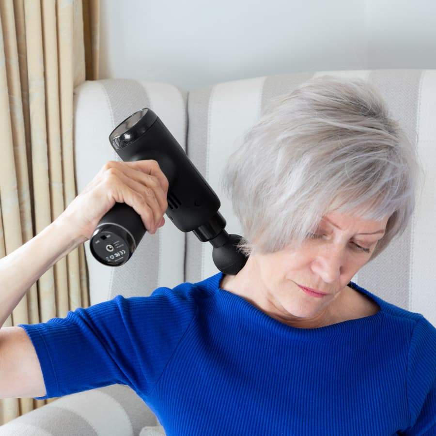 Woman using the Massage Therapy Gun on her neck 