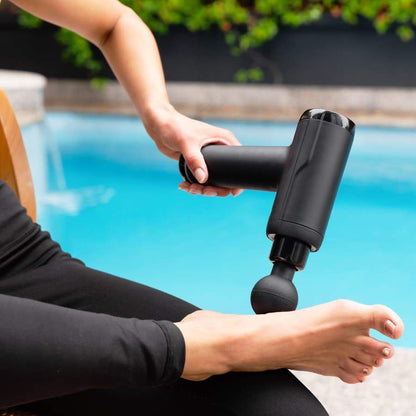 Person massaging their foot with the Massage Therapy Gun