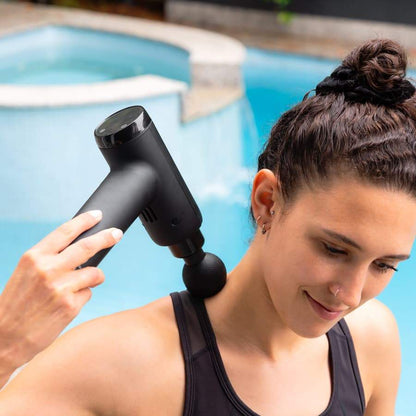 Young woman using the Massage Therapy Gun to massage her neck 