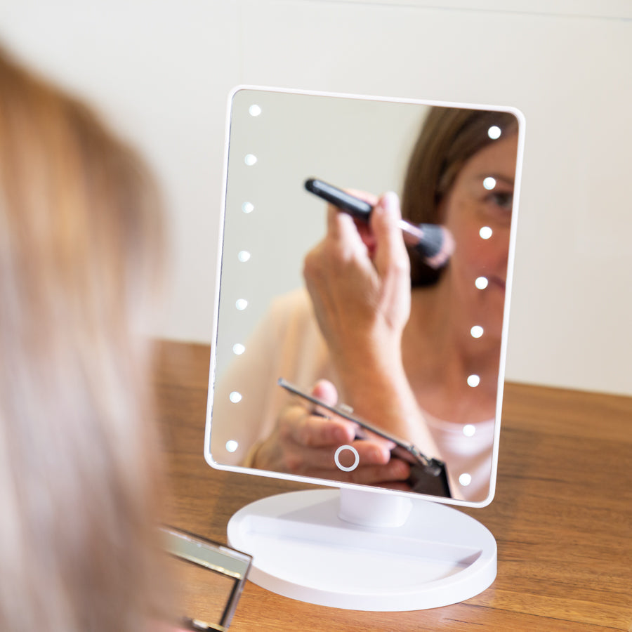 Woman putting on makeup with the White full frame adjustable mirror 
